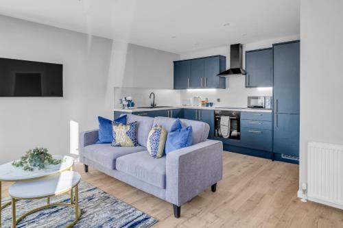 a living room with a blue couch and a table at King Street Stay - SJA Stays - Luxury 2 Bed Apartment in Aberdeen