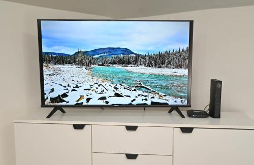 a tv sitting on a white cabinet with a television screen at Sunset Apartment in Smederevo