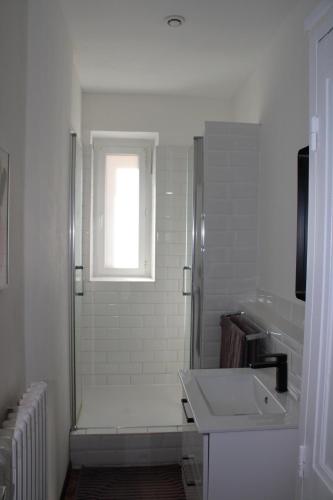 baño con ducha, lavabo y ventana en Superbe appartement avec parking sur place, en Nimes