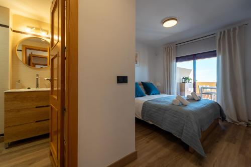 a bedroom with a bed and a bathroom with a window at Cala Azul Unique in La Cala de Mijas
