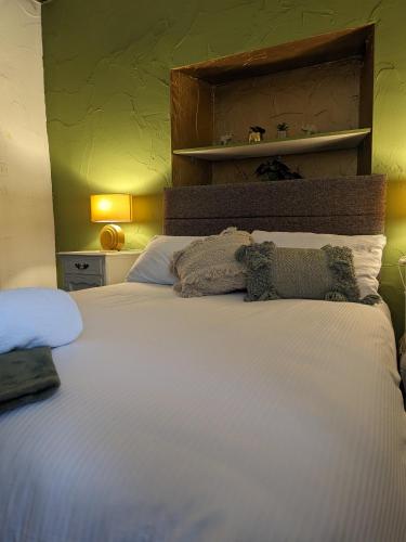 a bedroom with a large bed with white sheets at The Bay Horse Hotel Wolsingham in Wolsingham