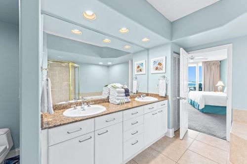 un bagno con due lavandini e una camera con un letto di Caribe Resort Unit B603 a Orange Beach