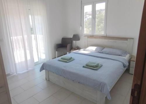 a bedroom with a bed with two towels on it at Adriatic Family House in Utjeha