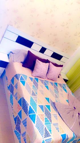 アグアドゥルセにあるHABITACIÓN & Confort JPのカラフルな枕が付いたベッド1台が備わる客室です。