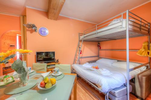 a bedroom with a bunk bed and a table with fruit on it at Studio Borgata Ski In Ski Out 300m - Happy Rentals in Sestriere