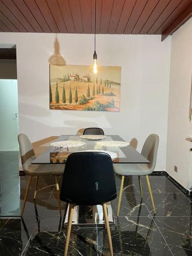 a dining room table with chairs and a painting on the wall at Ferienwohnung Wilusa 2 - Self Checkin in Rheinfelden