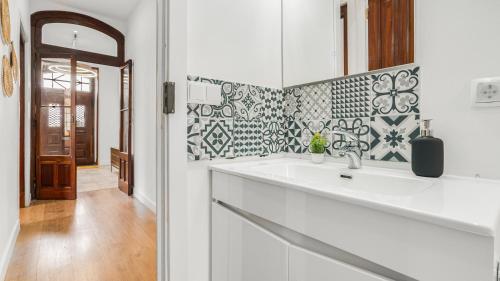 uma cozinha branca com um lavatório e um espelho em Sintra Retreat Residences 3 by LovelyStay em Sintra