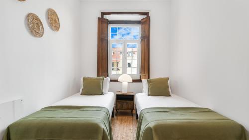 Duas camas num quarto com uma janela em Sintra Retreat Residences 3 by LovelyStay em Sintra