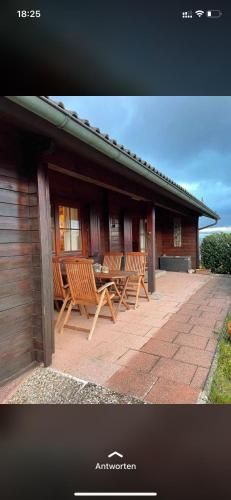 two chairs and a table in front of a building at Blockhaus FerienZauber II in Bromskirchen