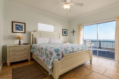 a bedroom with a bed and a view of the ocean at CR Escape in Dauphin Island