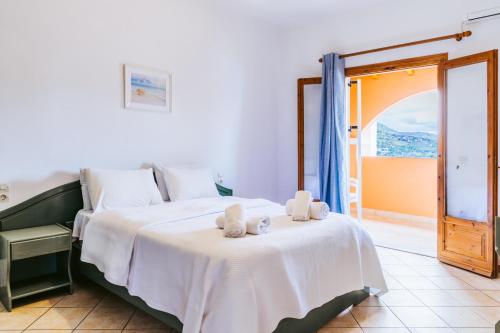 a bedroom with a bed with towels on it at Porto Kassiopi Apartments in Kassiopi