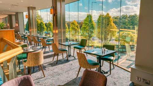 a restaurant with tables and chairs and a large window at Plaza Hotel Tallaght in Tallaght