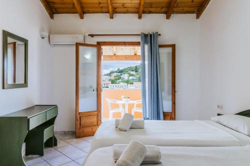 a bedroom with two beds and a view of the ocean at Porto Kassiopi Apartments in Kassiopi