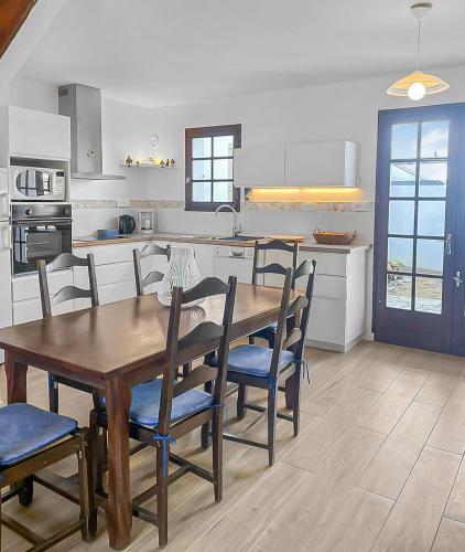 une cuisine avec une table et des chaises en bois dans l'établissement Havre de Lumière à La Barre-de-Monts, à La Barre-de-Monts