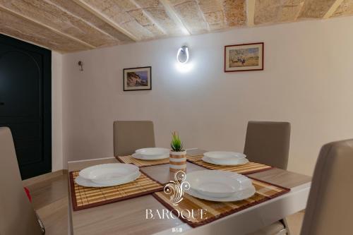 a dining room table with white plates on it at Baroque B&B in Lecce