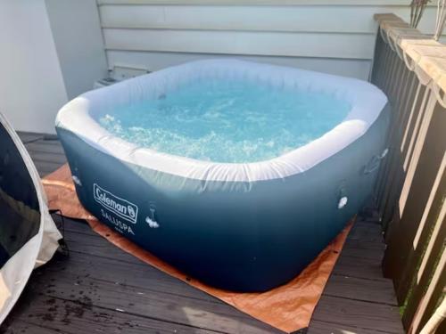 森林公園的住宿－Queen Suite - Hot Tub - Wifi Room 2，一个大蓝色的浴缸,坐在毯子上