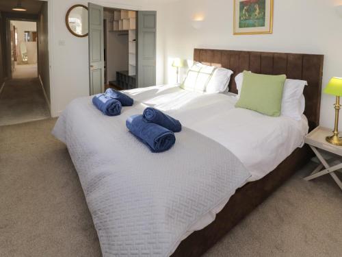 a bedroom with a large bed with blue towels on it at Home Farm Cottage in Southam