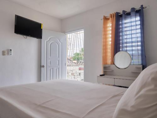 1 dormitorio con cama, espejo y ventana en Lovely and peaceful stay, en San Pedro de Macorís