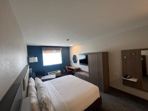 a hotel room with a bed and a couch at Holiday Inn Express - Wichita North - Park City, an IHG Hotel in Park City