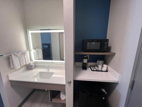 a bathroom with a sink and a microwave at Holiday Inn Express - Wichita North - Park City, an IHG Hotel in Park City
