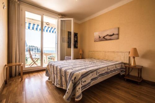 une chambre avec un lit et une grande fenêtre dans l'établissement Cassis - Appartement T3 Climatisé et vue mer, à Cassis