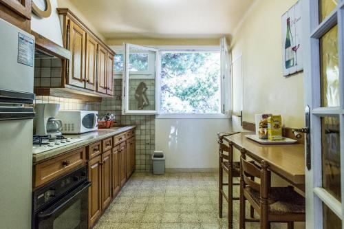 une cuisine avec des armoires en bois et une fenêtre dans l'établissement Cassis - Appartement T3 Climatisé et vue mer, à Cassis