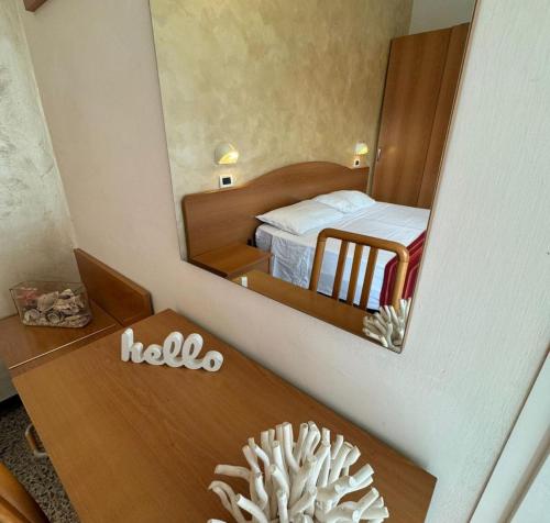 una camera d'albergo con specchio e letto di Hotel Caruso a Rimini