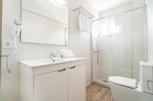 a white bathroom with a sink and a shower at New Kensington Apartments - Econotels in Magaluf