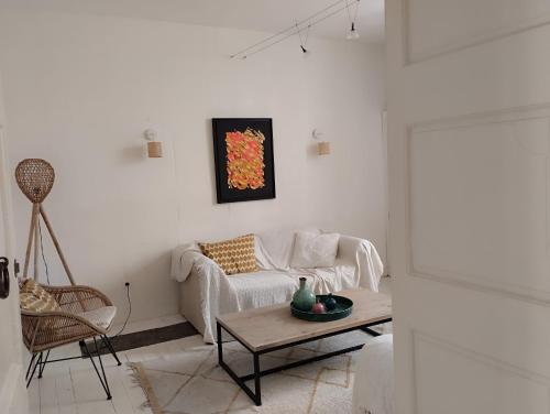 a white living room with a couch and a table at LE PATIO in Grignan
