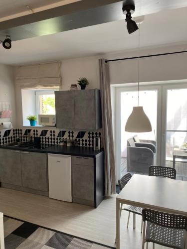 a kitchen with a table and a dining room at Apartament Natalia in Mrągowo