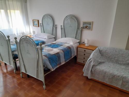 a bedroom with two beds and a dresser at Casa Valerio in Varenna