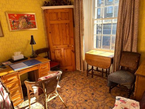 um quarto com uma secretária, uma janela e uma mesa em Very central 2 bedroom flat in World Heritage Site em Edimburgo