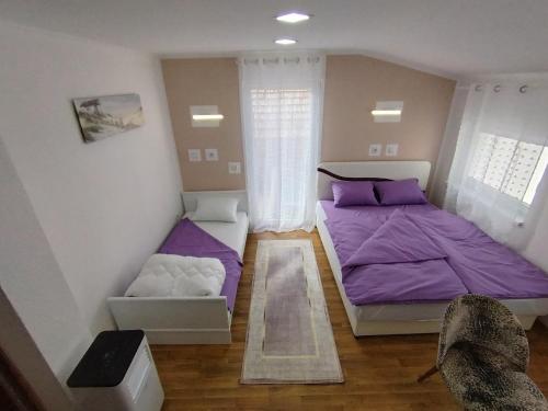 une petite chambre avec des lits violets et une fenêtre dans l'établissement Sarajevo Old Town 7, à Sarajevo