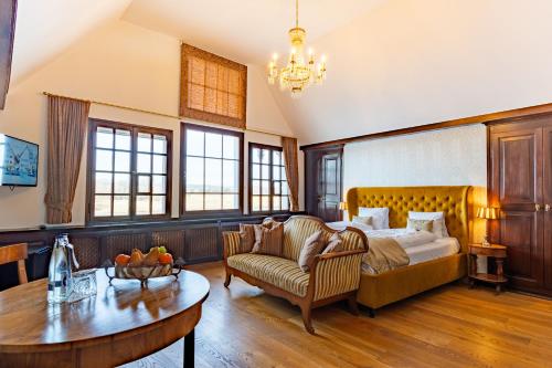 ein Schlafzimmer mit einem Bett, einem Sofa und einem Tisch in der Unterkunft Hotel Porto Sofie Gottlieben in Gottlieben
