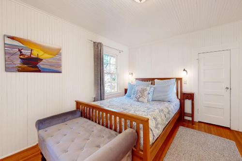 a bedroom with a bed with a bench in it at Captain John's Cannon Beach in Cannon Beach