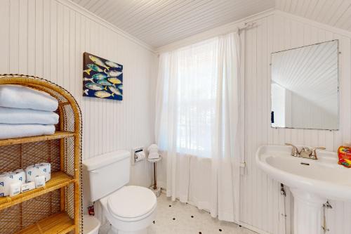 uma casa de banho com um WC branco e um lavatório. em Captain John's Cannon Beach em Cannon Beach