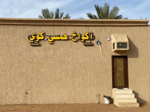 una señal en el lateral de un edificio en اكواخ همسي كوي, en Tabuk