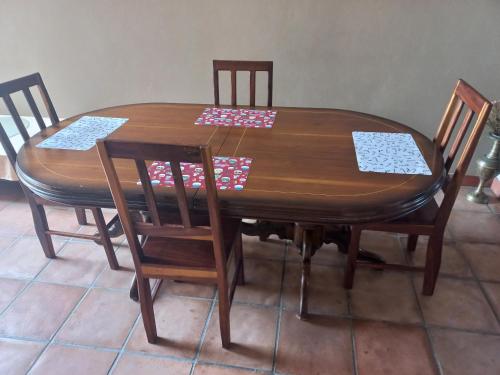 una mesa de madera con 4 sillas y una mesa con servilletas. en Sand and Sea, en Swakopmund