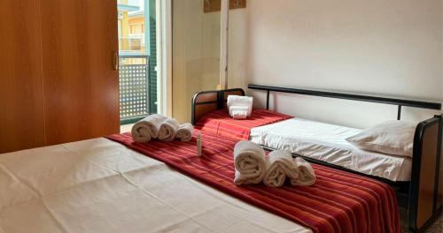 2 letti con asciugamani in una camera d'albergo di Hotel Caruso a Rimini