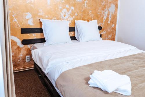 1 Schlafzimmer mit 2 Betten und weißer Bettwäsche in der Unterkunft Casa Rosu in Cluj-Napoca