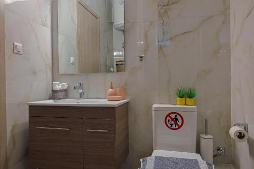 a bathroom with a sink and a toilet and a mirror at Zeta-Garden Oasis & Private Parking by Optimum Link in Katerini