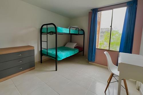 a bedroom with bunk beds and a desk and a window at GURUS FR | Hermoso Apto. familiar con terraza | Santa Rosa in Santa Rosa de Cabal