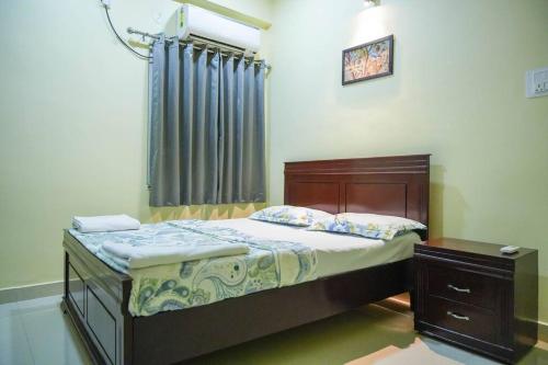 a small bedroom with a bed and a window at Classe Moyenne -2BHK, Near US Embassy, Gachibowli in Hyderabad