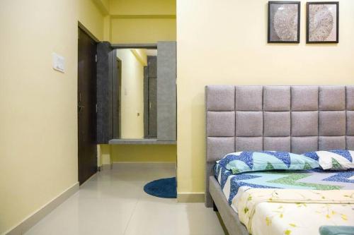 a bedroom with a bed and a mirror on the wall at Classe Moyenne -2BHK, Near US Embassy, Gachibowli in Hyderabad