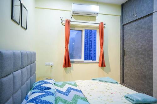 a bedroom with a bed and a window at Classe Moyenne -2BHK, Near US Embassy, Gachibowli in Hyderabad