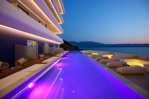 a swimming pool with purple lights on the side of a building at Regina Blu in Vlorë