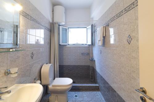 ein Bad mit einem WC, einem Waschbecken und einer Dusche in der Unterkunft Nikos Cassiopeia in Kassiopi