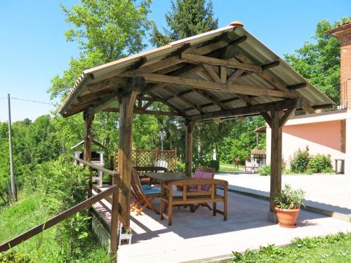 a wooden gazebo with a table and a bench at Holiday Home Il Cavaliere by Interhome in Castellero