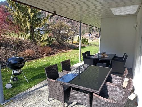 un patio avec une table, des chaises et un grill dans l'établissement Apartment Schmidt - VNN140 by Interhome, à Vandans