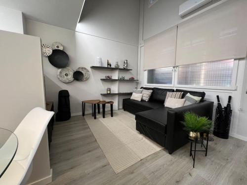 ein Wohnzimmer mit einem schwarzen Sofa und einem Tisch in der Unterkunft Loft en Barcelona in Barcelona
